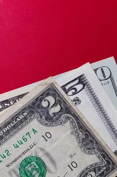 Three US dollar bills layered to form number 250 on a red background. Financi Stock Photos