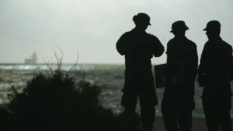 Three U.S. marines waiting on the beach for the ship Stock Footage 117734918