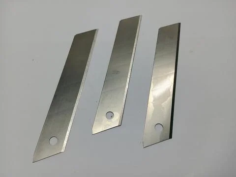 Three Utility Knife Replacement Blades Vertically Arranged on White Background 库存照片