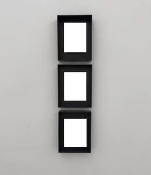 Three vertical black frames arranged in a column on a light wall. The frame.. Stock Photos