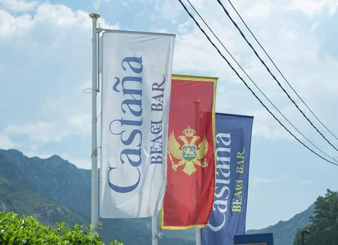 Three vertical flags, including the national flag of Montenegro, on flagpoles Stockfoto's
