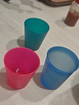 Three Vibrant Plastic Cups in Blue, Teal, and Pink Stock Photos