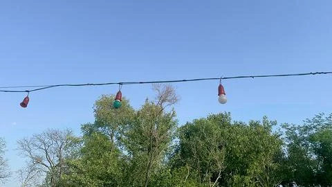 Three Vintage bulb light attach with wire in an open blue sky Stock-Fotos