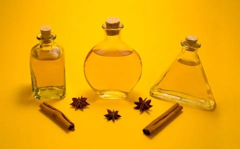 Three vintage glass bottles with spice on bright orange background Stock Photos