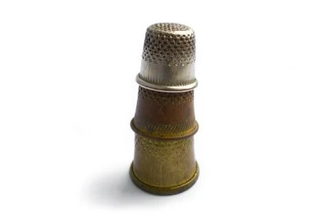 Three vintage thimbles stand in a column on top of each other Stock Illustration