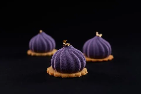 Three violet cakes with matte surface isolated on black. Stock Photos