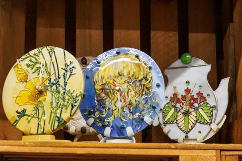Three wall clocks made using stained glass technique on shelf in art shop. .. Stock Photos