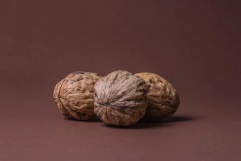 Three Walnut walnuts on a dark brown background Stock Photos