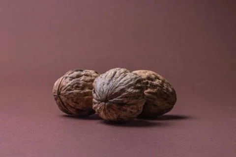 Three Walnut walnuts on a dark brown background Stock Photos