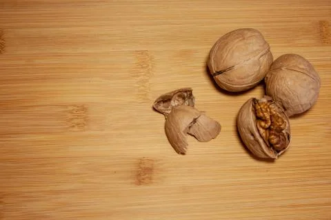 Three walnuts are lying on a bamboo Board Stock Photos