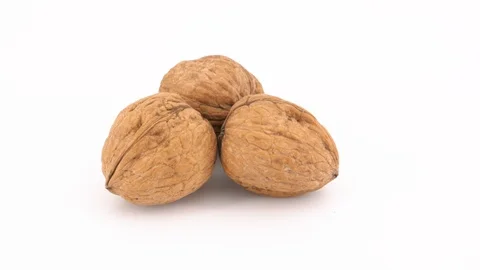 Three walnuts isolated rotating on white background Stock Footage 85925604