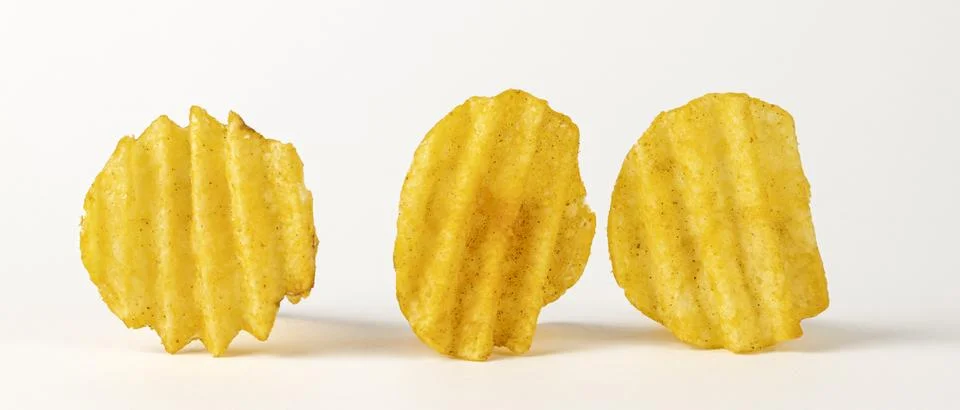 Three wavy chips on a white background with a cropped outline. Corrugated potato Stock Photos