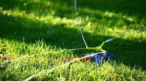 Three-way sprinkler in garden Stock Footage 26174067