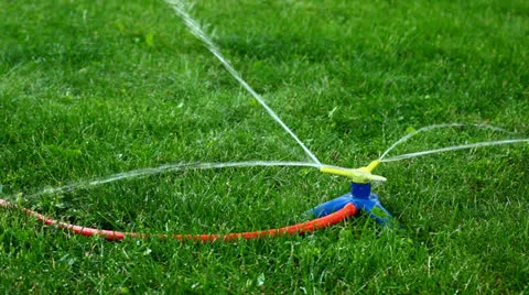 Three-way sprinkler in garden Stock Footage 26174774