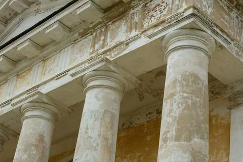 Three weathered neoclassical columns support an aged entablature, showing Foto stock