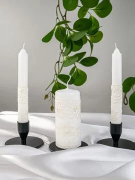 Three wedding candles on a gray background in the interior, festive still lif Stock Photos