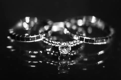 Three wedding ring on the reflecting surface with highlights Stock Photos