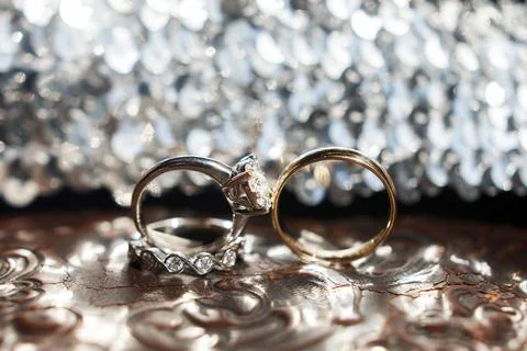 Three wedding rings on the reflecting surface with highlights Stock Photos
