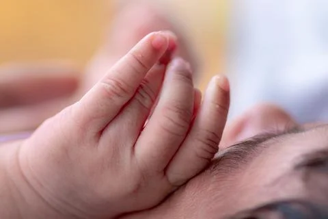 Three weeks old adorable infant baby girl's hand on her face, sleeping cute s Stock Photos