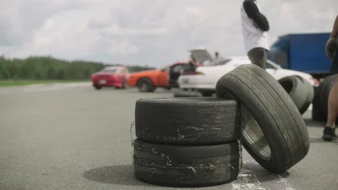 Three wheels stack. Man puts a tire next to others it bounces a couple of times Stock-Footage 129345812
