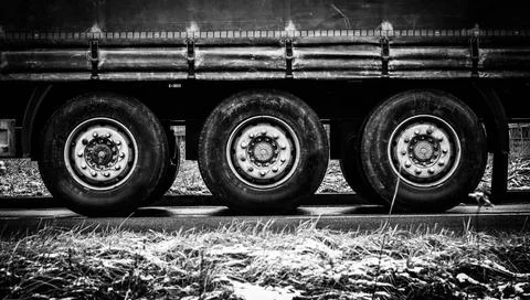 Three wheels of tilt semi-trailer Symetric image of three axes with wheels... Stock Photos