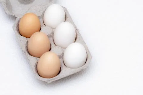 Three white and three brown eggs in a cardboard tray Stock Photos
