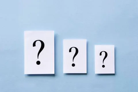 Three white cards with printed question marks Stock Photos