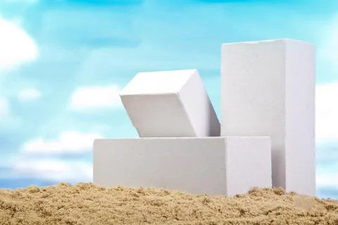 Three white ceramic bricks on the sand at the blue sky background Stock Photos