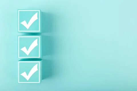 Three white checkmarks on blue cubes against bright pastel blue background with Stock Photos