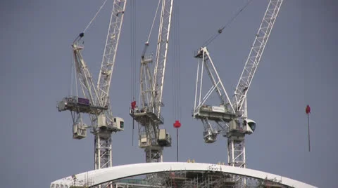 Three white cranes on top of building Stock Footage 25936706