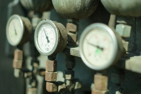 Three white dials on a pipe, one of which is showing the time Foto stock