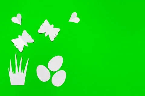 Three white easter eggs, grass, hearts and butterflies cut of paper on green  Stock Photos