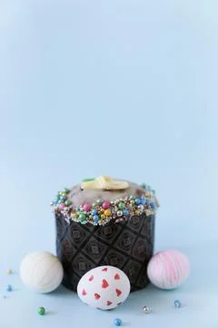 Three white Easter eggs with a pattern on the background of one cake with decor Stock Photos