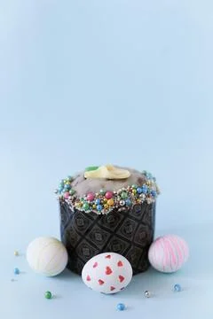 Three white Easter eggs with a pattern on the background of one cake with decor 스톡 사진