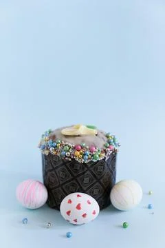 Three white Easter eggs with a pattern on the background of one cake with decor 스톡 사진