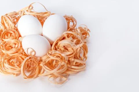 Three white Easter eggs in a saw Stock Photos