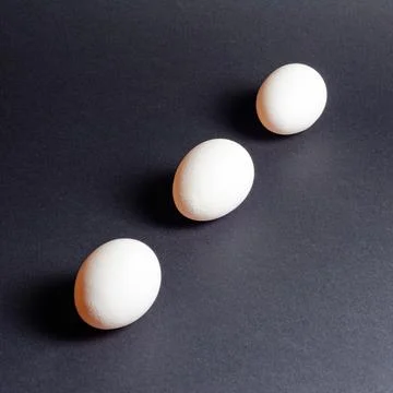 Three white eggs on a black background, dietary and healthy food rich in prot Foto stock