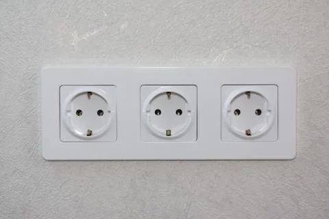 Three white electrical outlets on the wall Stock Photos