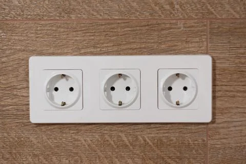 Three white electrical outlets on the wall Stock Photos