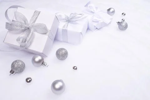 Three white gift boxes on artificial snow cover. Stock Photos