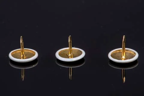 Three white pins on a black background with the tip up sharp and pointed Stock Photos