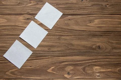 Three white post-in notes on wooden background Stock Photos