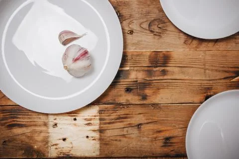 Three white round empty plates on dark brown wooden background, top view. Stock Photos