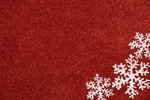 Three white snowflakes on a glitter red background. Stock Photos