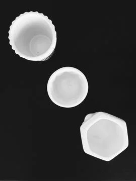 Three white vases on a black table Stock Photos
