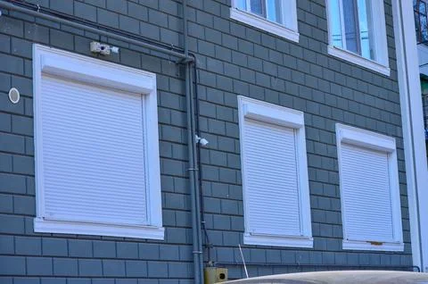 Three white windows on a gray brick wall. Foto stock