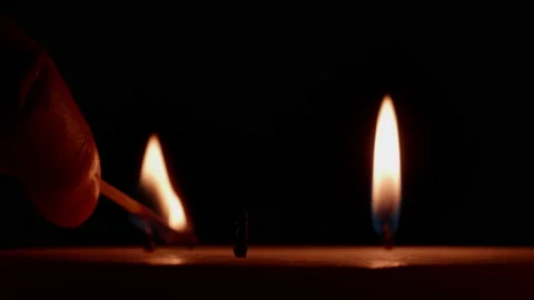 A three wick candle being lit - black background - close up. 4K locked tripod Stock Footage 144937494