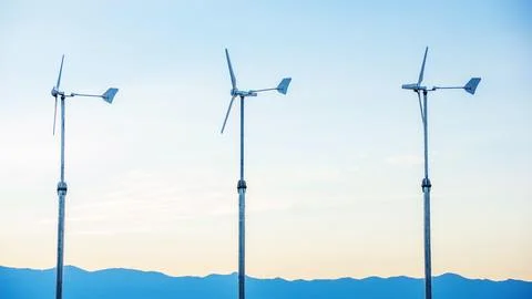 Three wind turbine in the sunset. Stock Photos