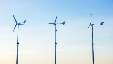 Three wind turbine in the sunset. Stock Photos