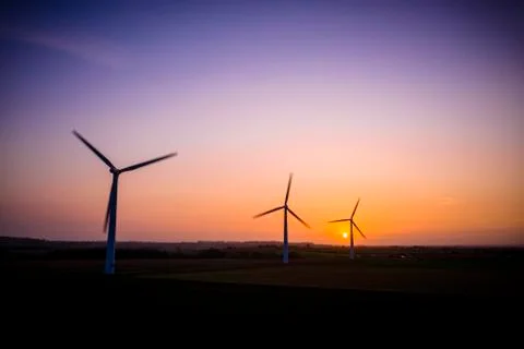 Three wind turbines with a dramatic sky at sunrise aerial, England 写真素材